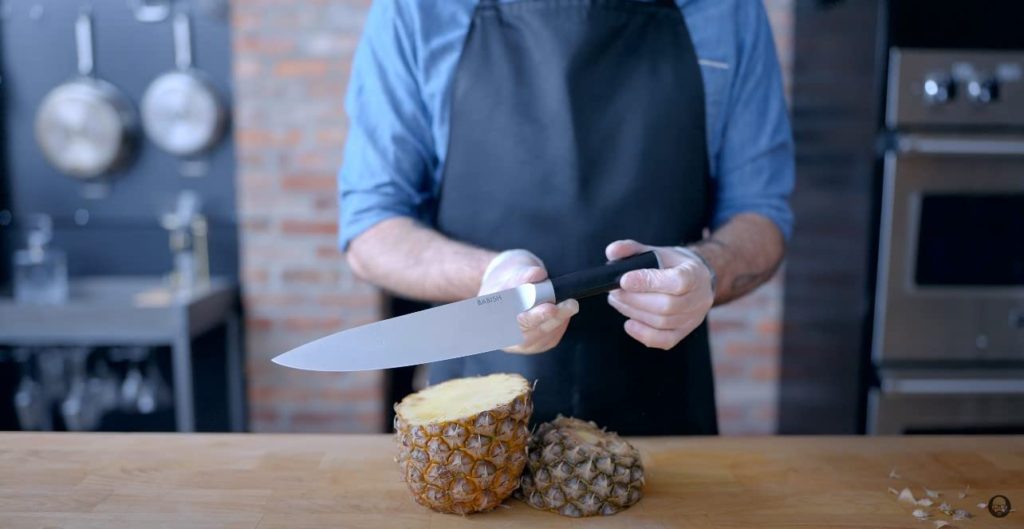 Chef knife with a pineapple cut in half