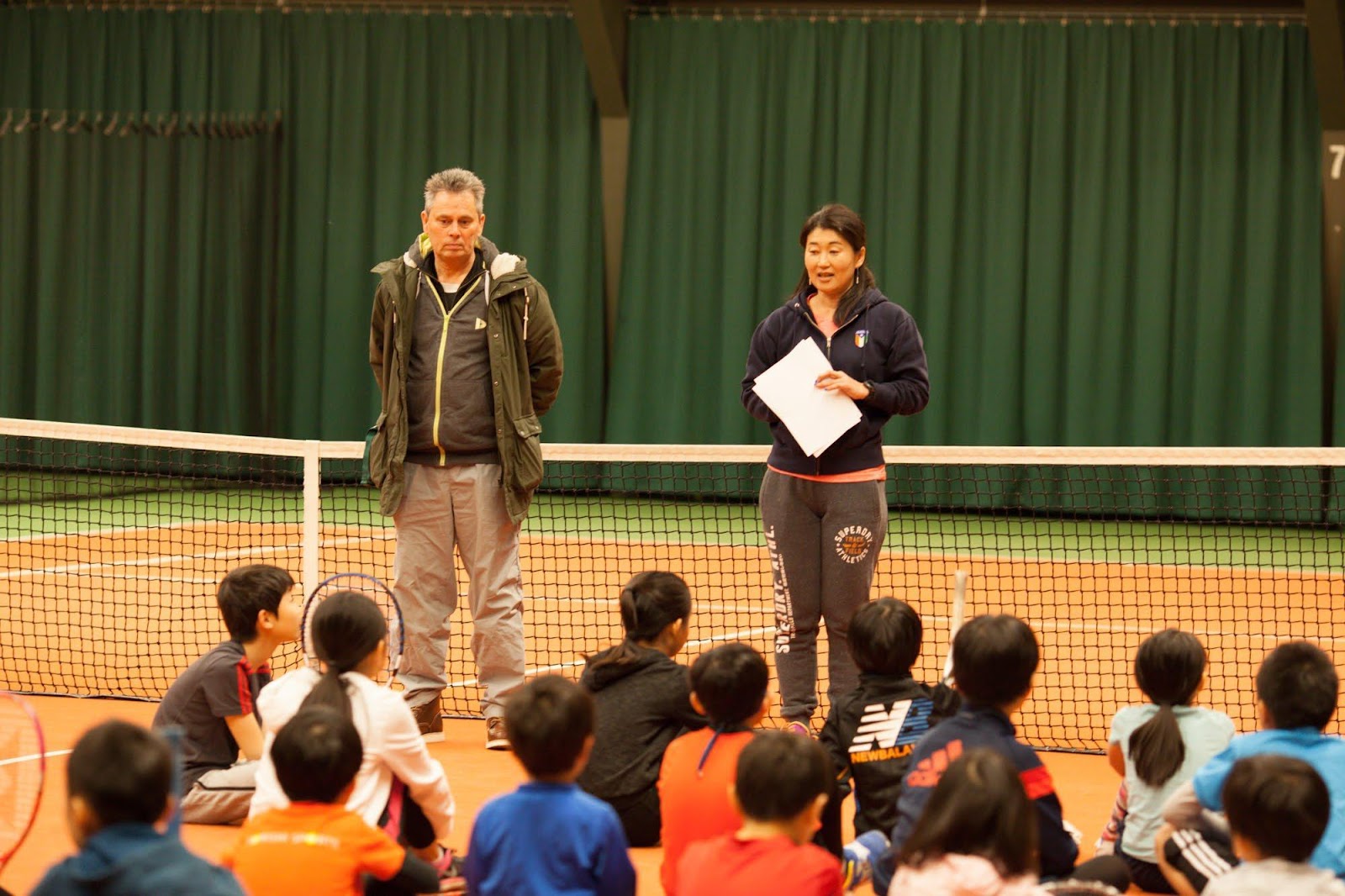 A person and person standing on a tennis court with a crowd watching

Description automatically generated with low confidence