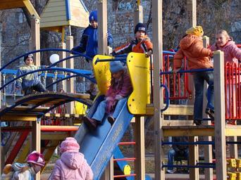 Photo of a playground with special needs children playing with their peers.