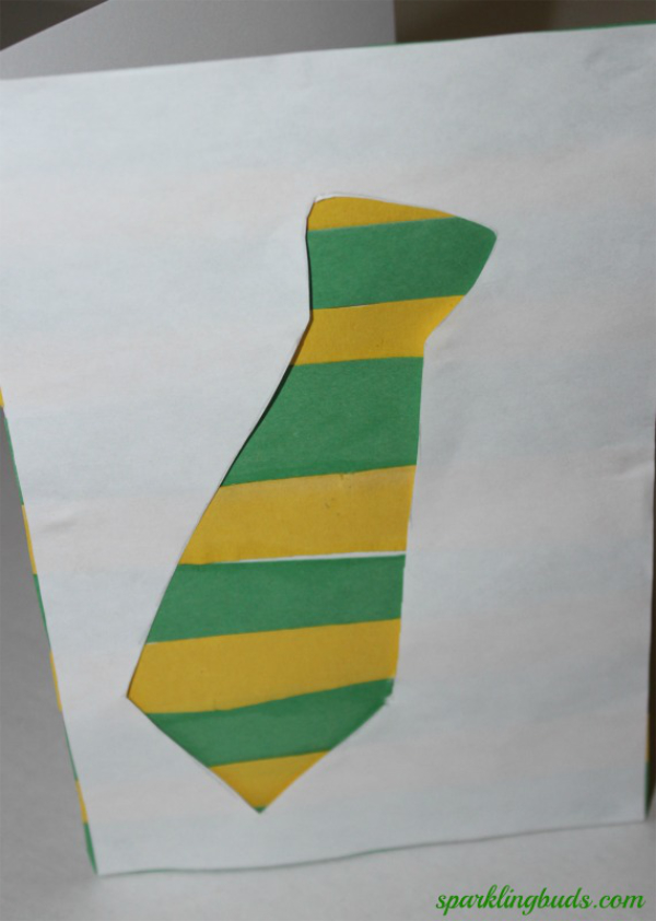 A Father's Day tie card with a green and yellow tie surrounded by blank white printer paper.