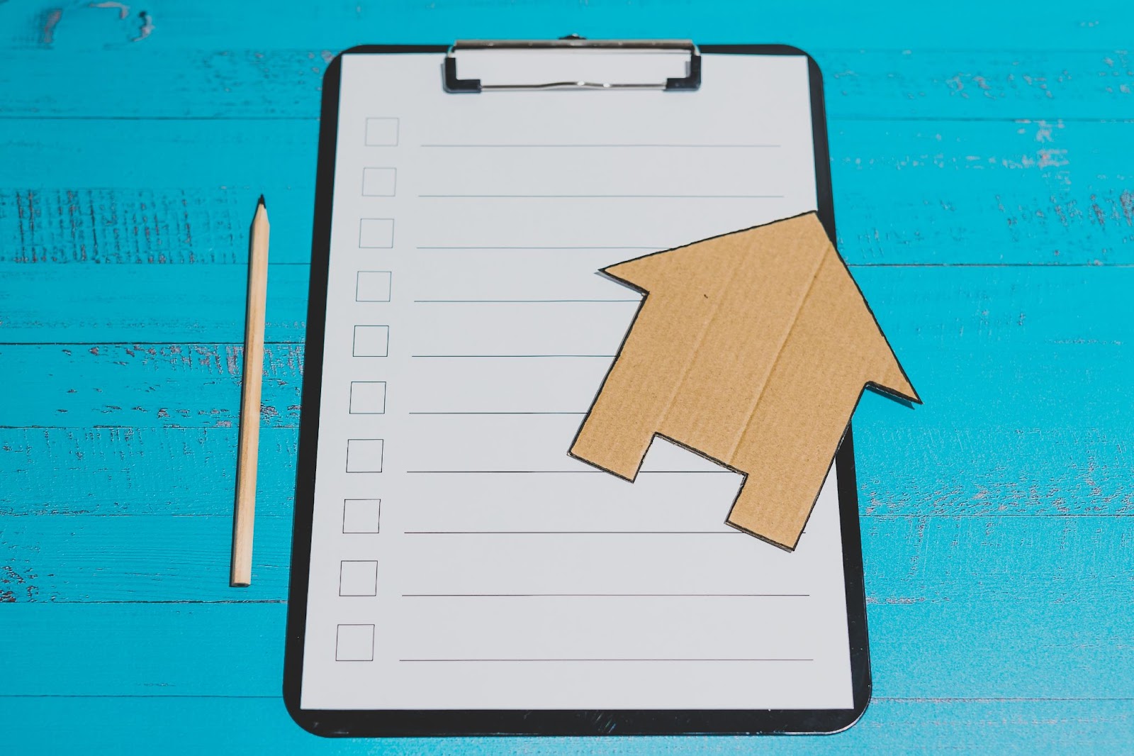 Image of a checklist with a cardboard house on top. From Turner Realty, finding homes for sale in Longmont, CO