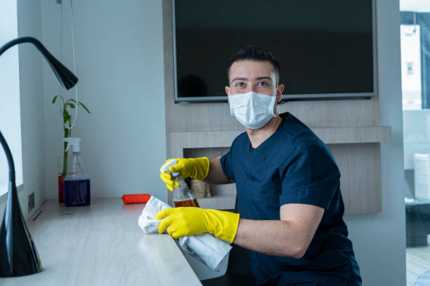 Average 25-year-old Latino man cleans hotel rooms he works for 28-year-old average Latino man dressed in a toilet uniform wearing his gloves and masks performs the cleaning of hotel rooms for work office toilet cleaning stock pictures, royalty-free photos & images