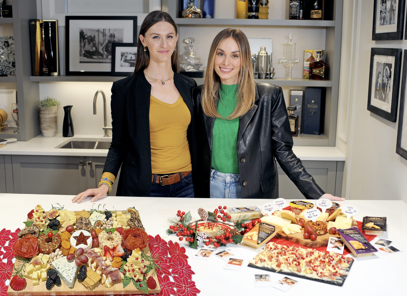 Two women standing next to a table with food on it

Description automatically generated with medium confidence