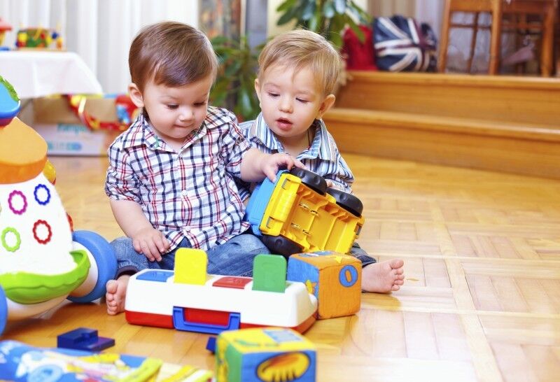 Kids playing with colorful blocks and trucks e1402088205854