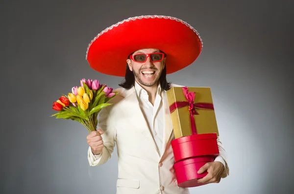 a mexican man holding a flower and gifts 