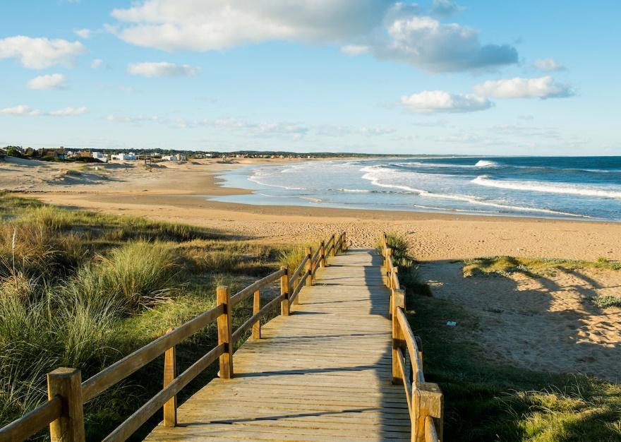 A sandy beach next to a body of water

Description automatically generated