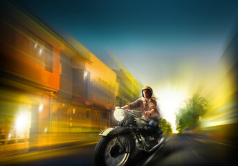 blurred photo of a motorcyclist riding at night down the street