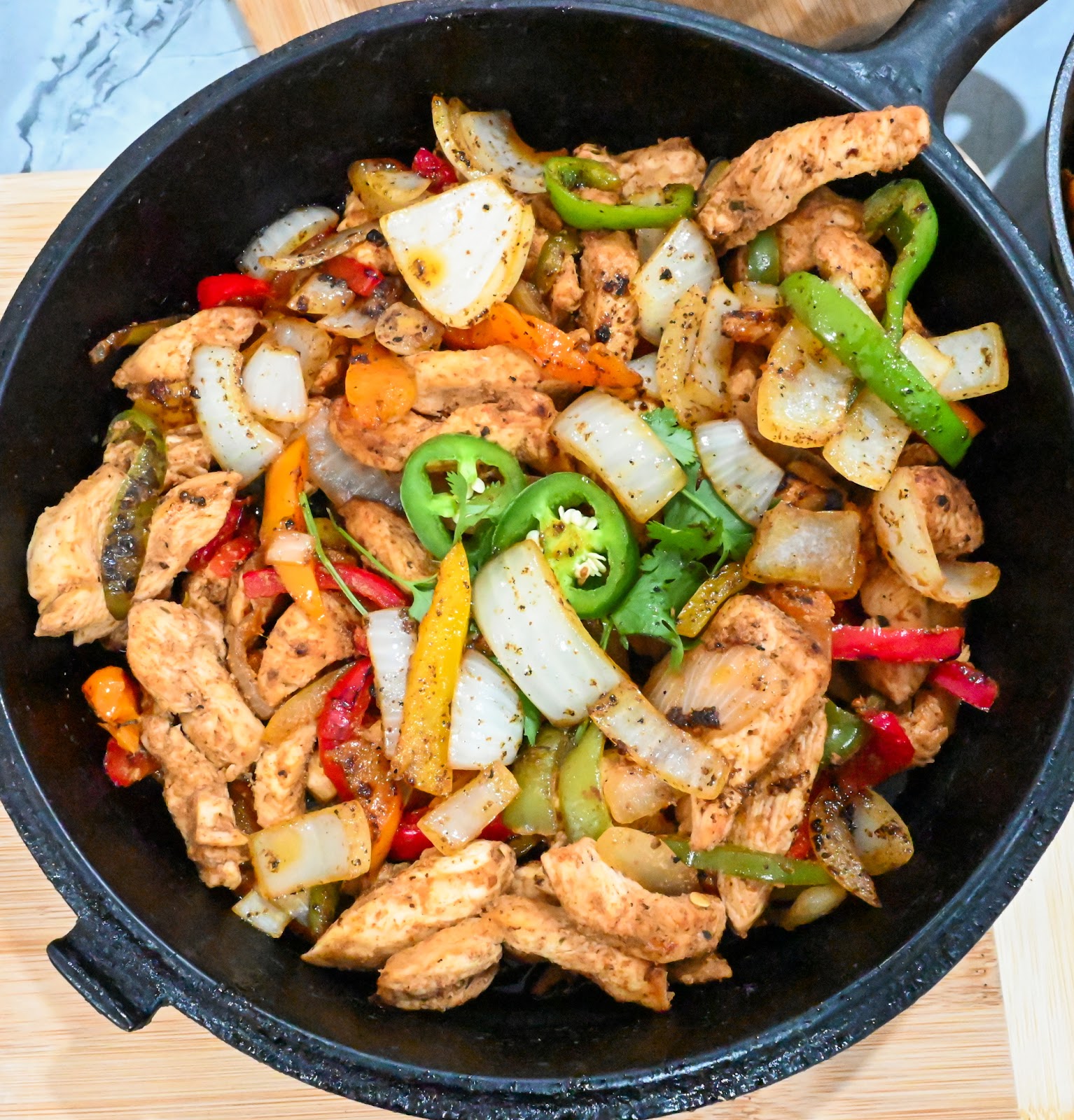 Keto chicken fajitas in a black cast iron skillet overhead shot