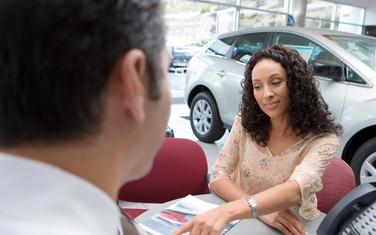 woman tries to Negotiate a car lease with retailer to get the best possible outcome