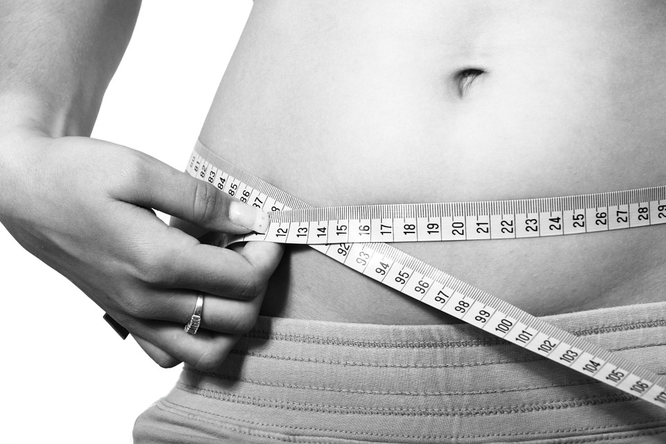 A closeup of a person measuring their stomach