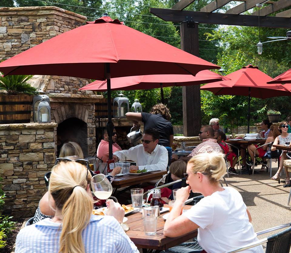 Image may contain: 3 people, people eating, people sitting, table, child, outdoor and food