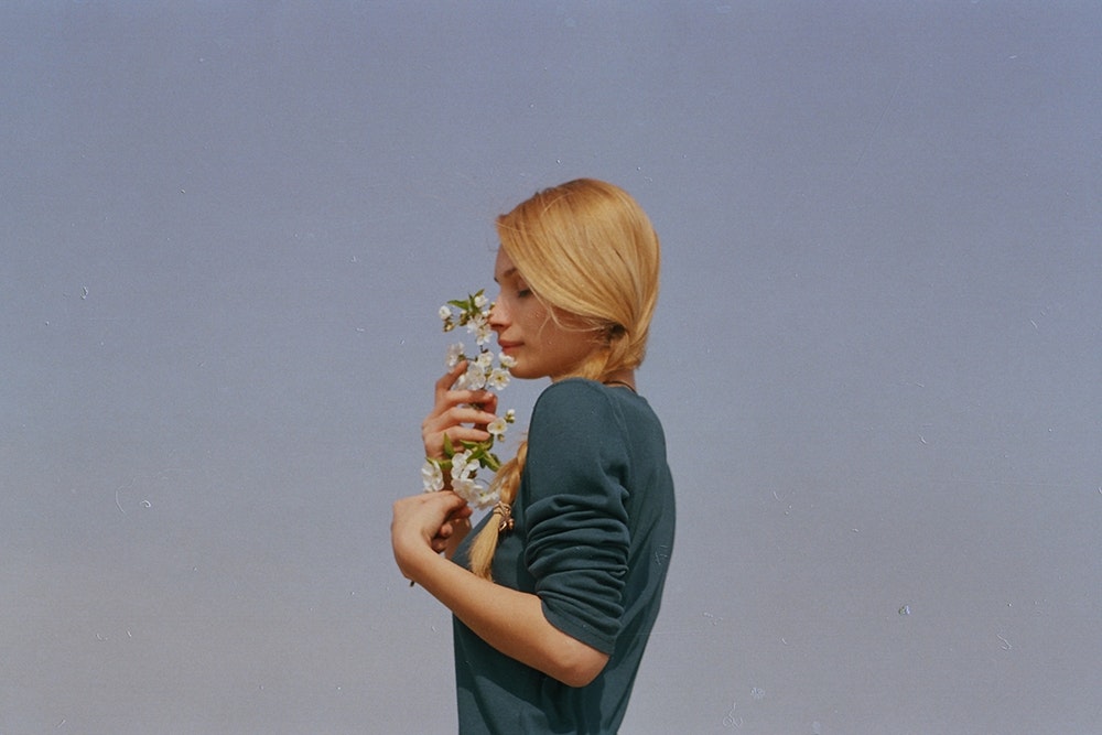 woman smelling white petaled flowers