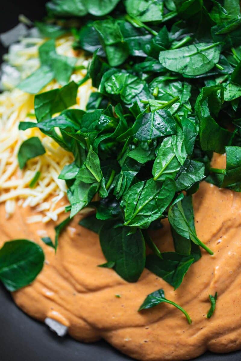 Vegetable pasta sauce and spinach in a pan