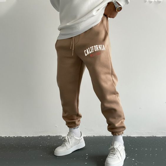 man earing brown sweat pants with white sneakers