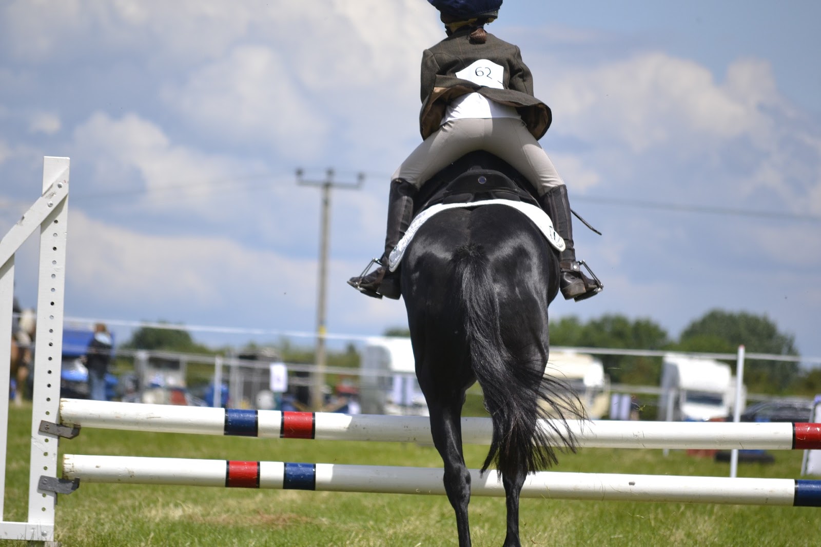 Small pony and rider jump a low vertical rail jump.