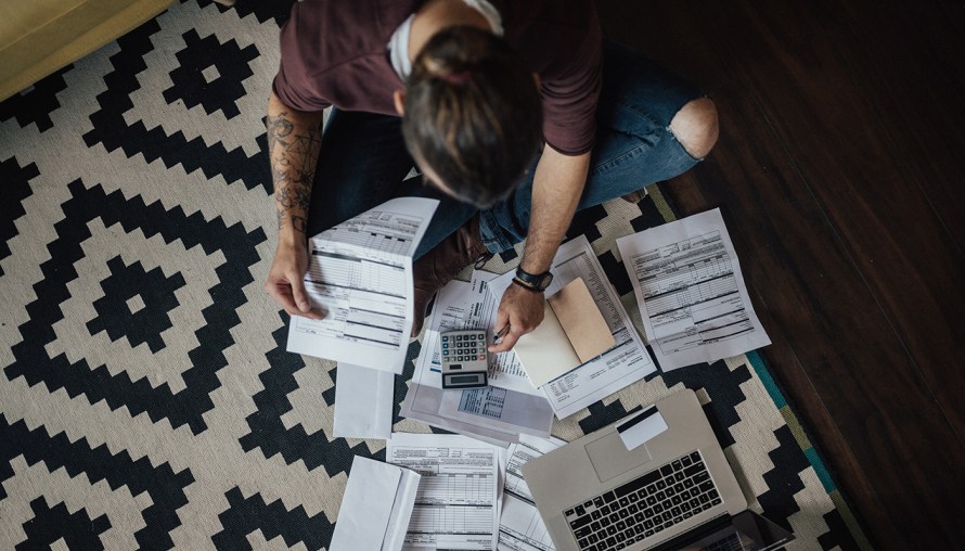 birds eye view of person calculating and doing work on a laptop