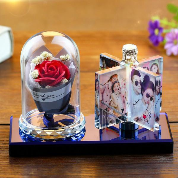 lampe portant une rose protégée par une coupole et 8 photos sur un présentoir tournant.