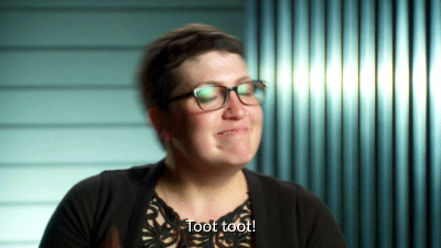 Giphy clip of a woman pretending to pull on a bell and saying "toot toot" with a smug smile.