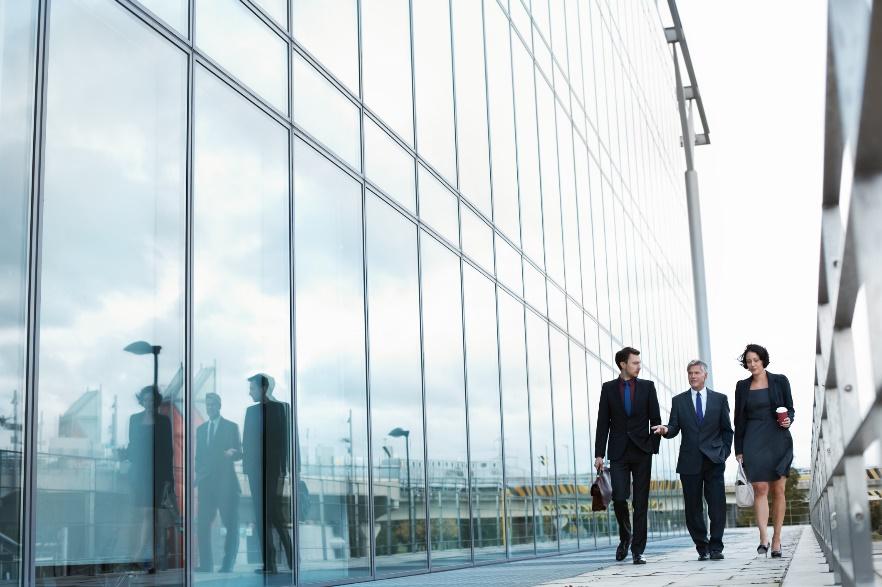 Three employees walking outside an office building that is certified bye the WELL Building Standards