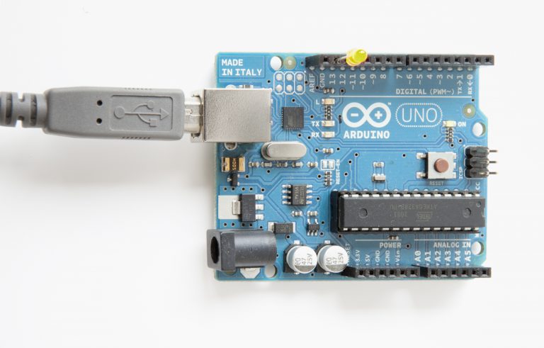 This is a blue Arduino Uno connected to a gray USB cable.