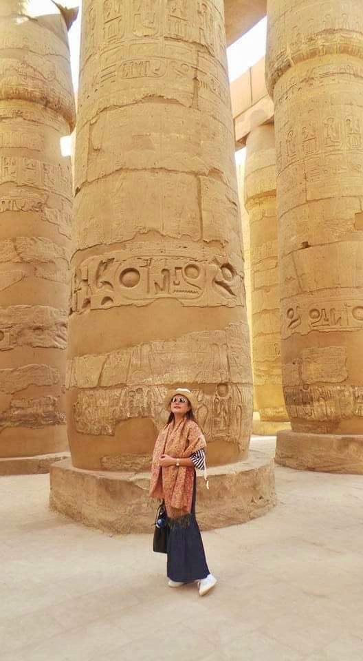 Image of Candy standing beneath towering columns of an ancient Egyptian temple