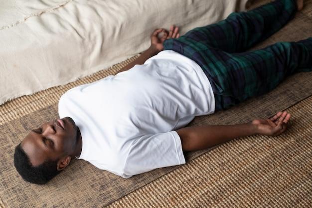 Premium Photo | Young black man lying in dead body exercise or corpse pose  with his eyes closed savasana pose working out resting after practice