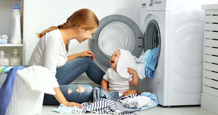 mãe-brincando-com-bebê-em-frente-a-uma-lavadora