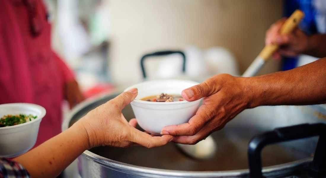 hands exchanging bowl at soup kitchen