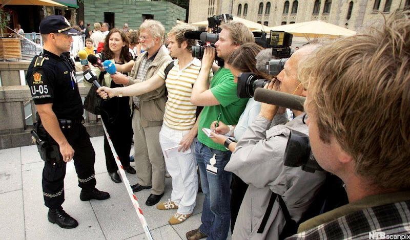 Politimann som snakker med pressen. Foto.
