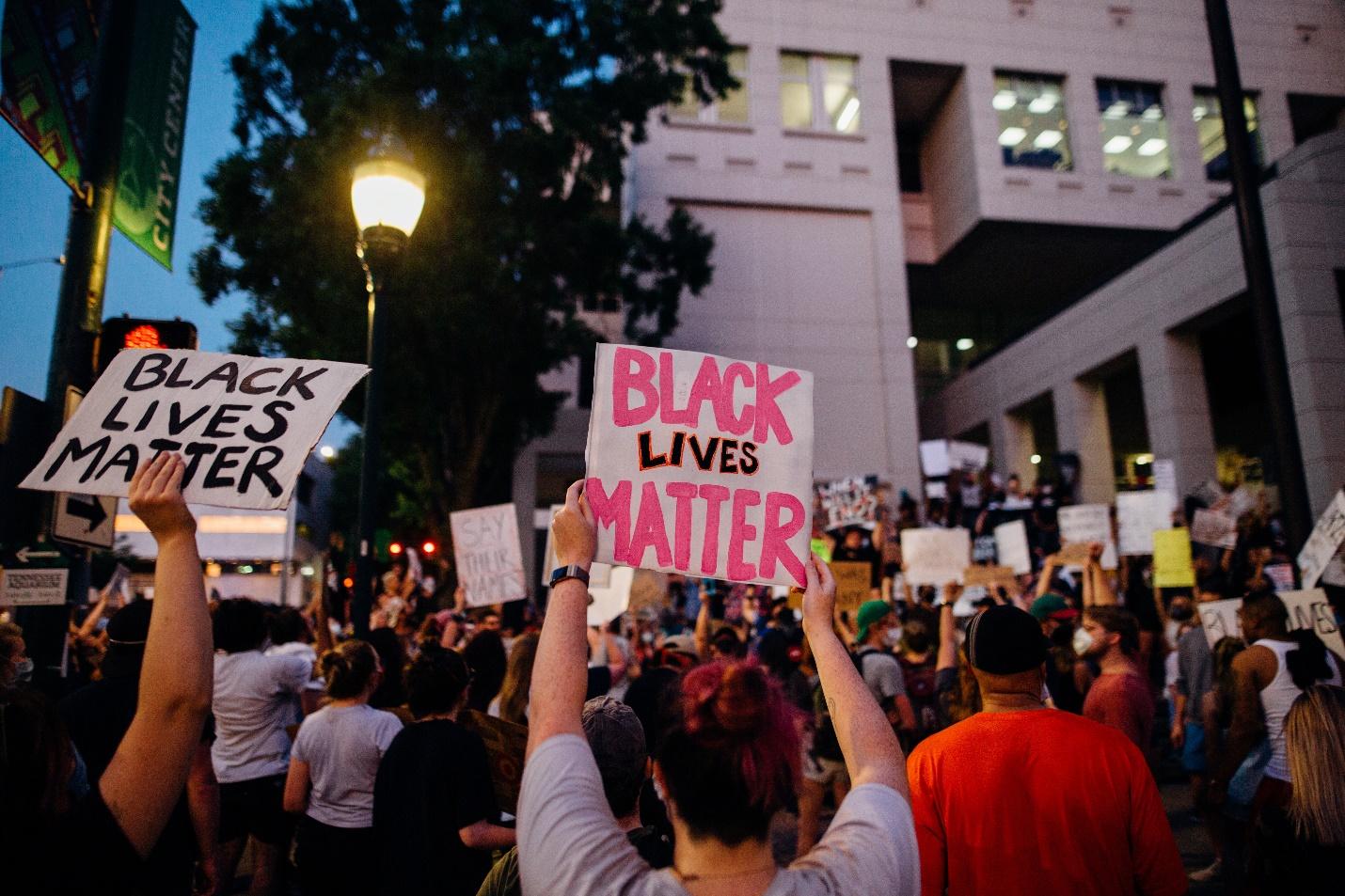 A crowd of people holding signs

Description automatically generated with medium confidence