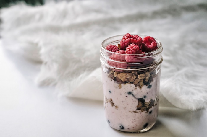 ausgewogene ernährung idee zum frühstück, hausgemachtes müsli mit joghurt und frisches obst, himbeere