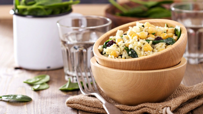 was heißt richtige ernährung, hier ein beispiel, die kleinen portionen sind gesund, schüssel, voll mit quinoa mit mais und spinat, gabel, wasser in einem glas