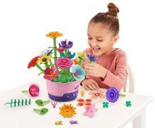 A child sitting at a table with a flower pot

Description automatically generated