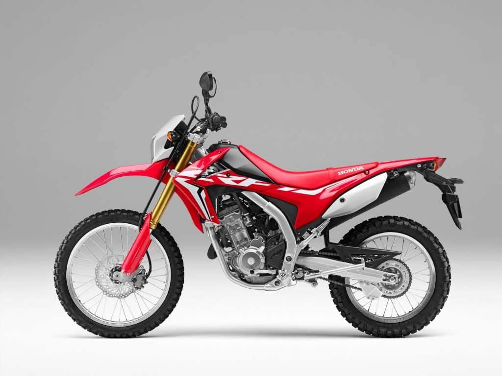 2023 Red Honda CRF250L: dual sport motorcycle parked on display in a showroom