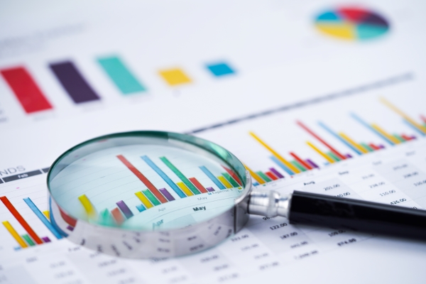 magnifying-glass-charts-graphs-spreadsheet-paper