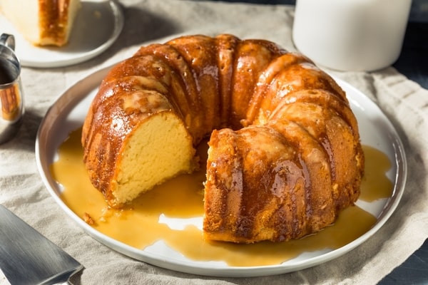 A sliced bundt cake covered in rum glaze and served in a plate