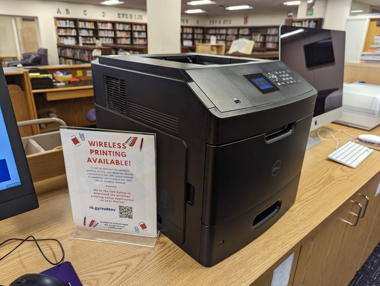 photo of office printer with a sign that says, "Wireless Printing Available!"