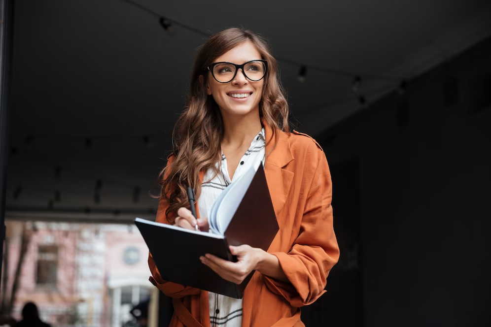 Consultor: O Guia Completo para Entender o Papel e a Importância dos Consultores: uma jovem profissional sorri enquanto escreve em seu caderno