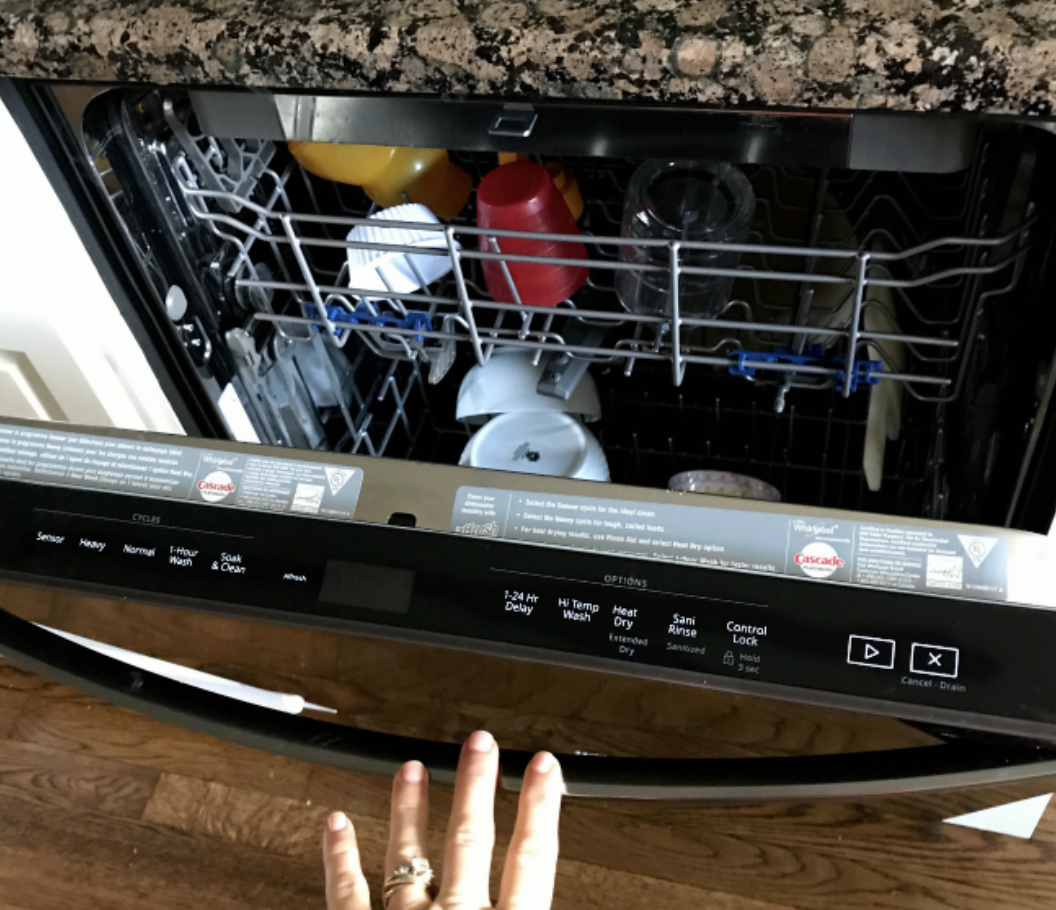 A close up of an open dishwasher.