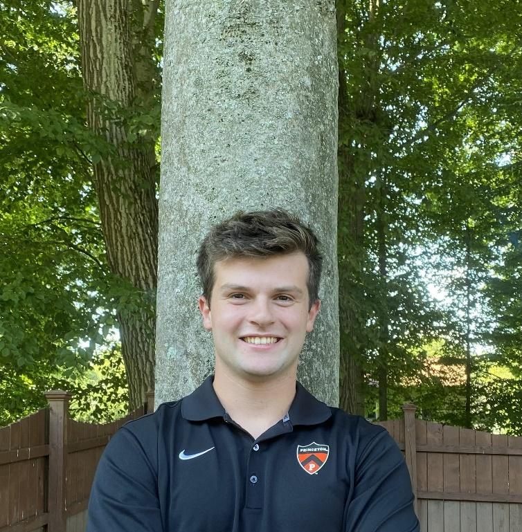 A person standing next to a tree

Description automatically generated