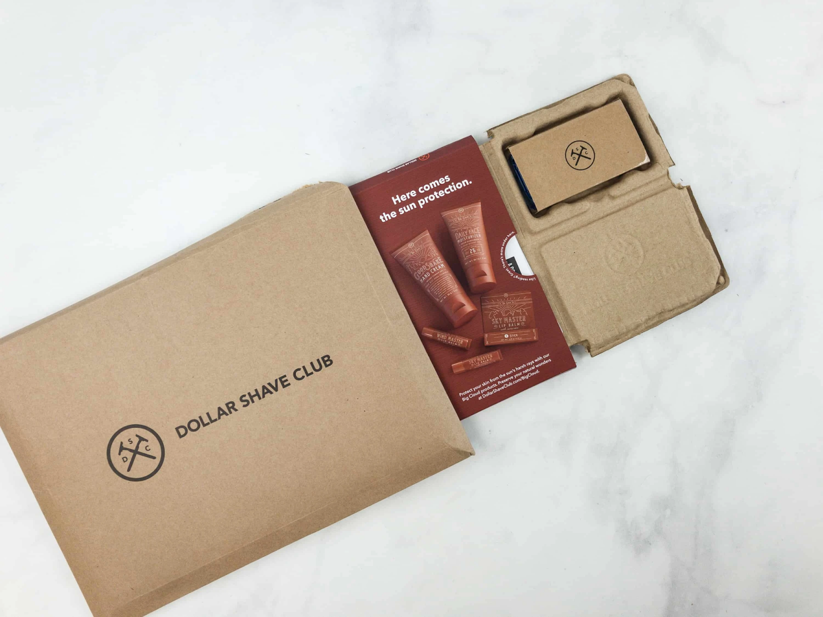Dollar Shave Club brown cardboard box with logo printed on top and products inside