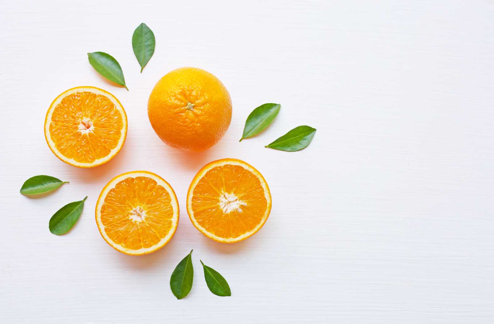 Orange halves sliced lying artfully on white background