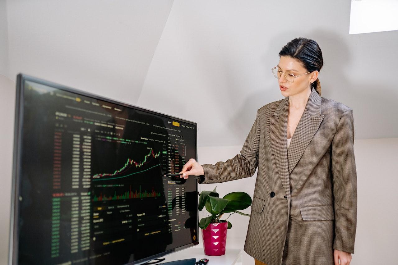 A woman pointing to market research data on a screen.