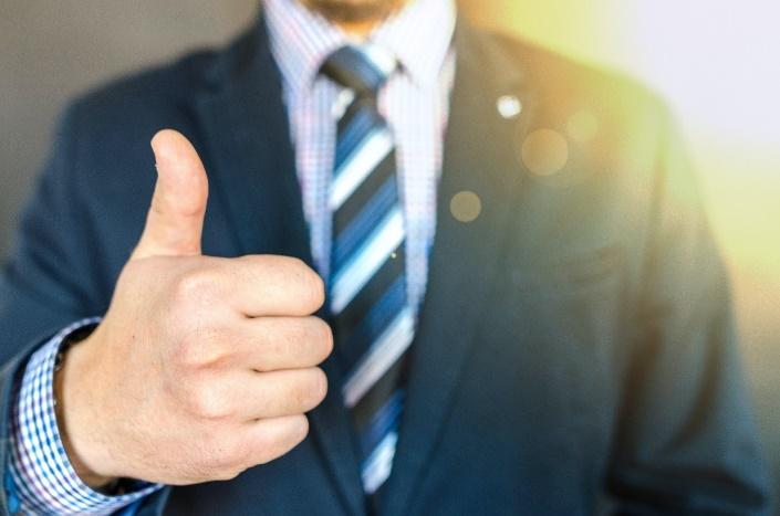 A person in a suit giving a thumbs up

Description automatically generated with low confidence