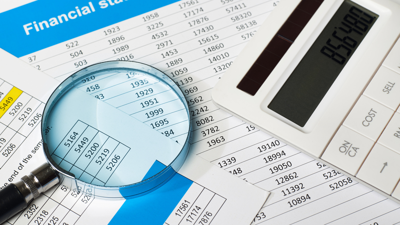 Financial statements, a calculator and a magnifying glass