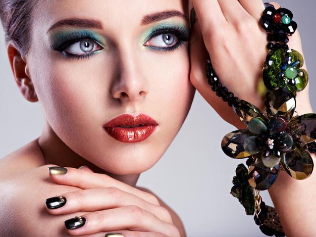 Rosto de mulher bonita com maquiagem verde fashion e joias disponíveis Foto gratuita