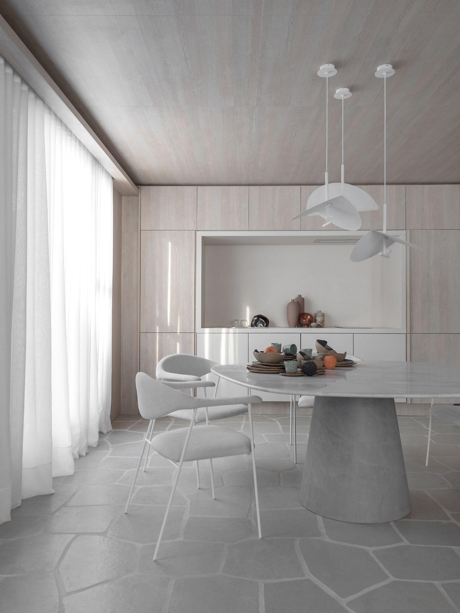Cozinha moderna com piso geométrica cinza, mesa redonda com cadeiras cinzas, luminárias pendentes sob a mesa branca, armários em tom nude e teto revestido com madeira nude