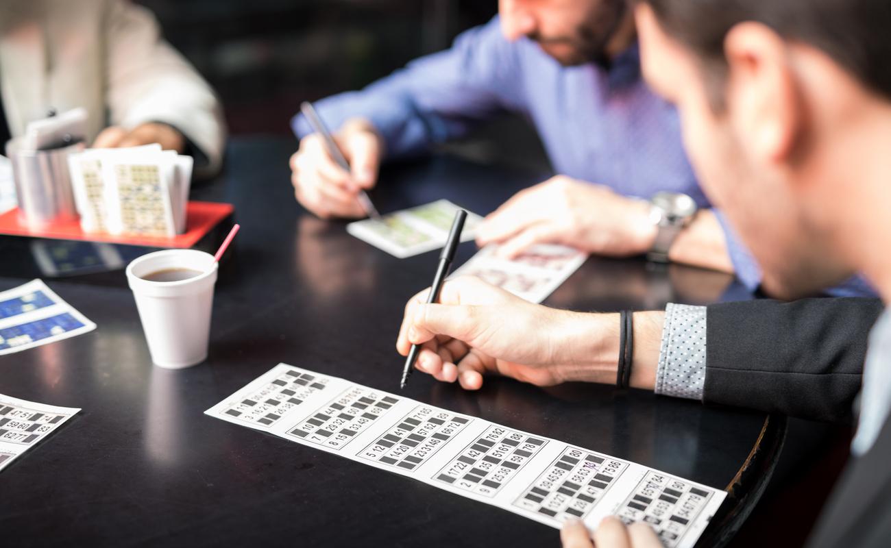 Hands of bingo players playing bingo