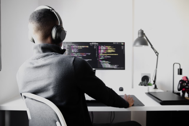 a man wearing headphones using a computer 