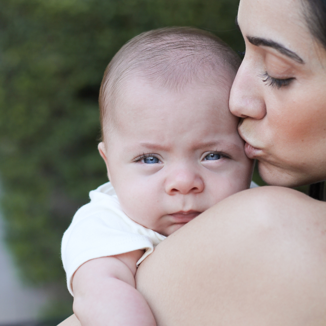 Mother cuddling her baby who is weaning